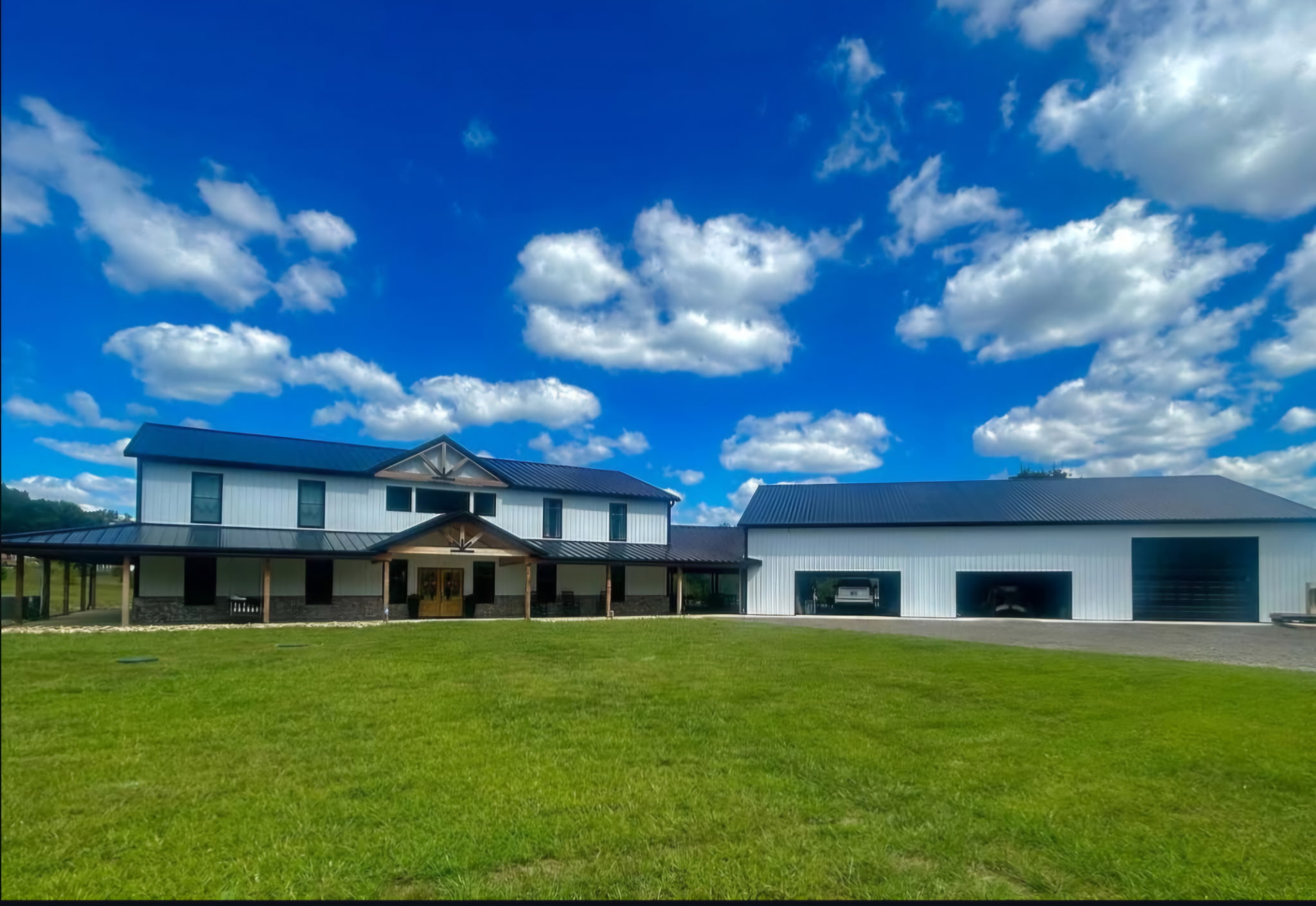 Large home and outbuilding with a completed dark metal roofing system